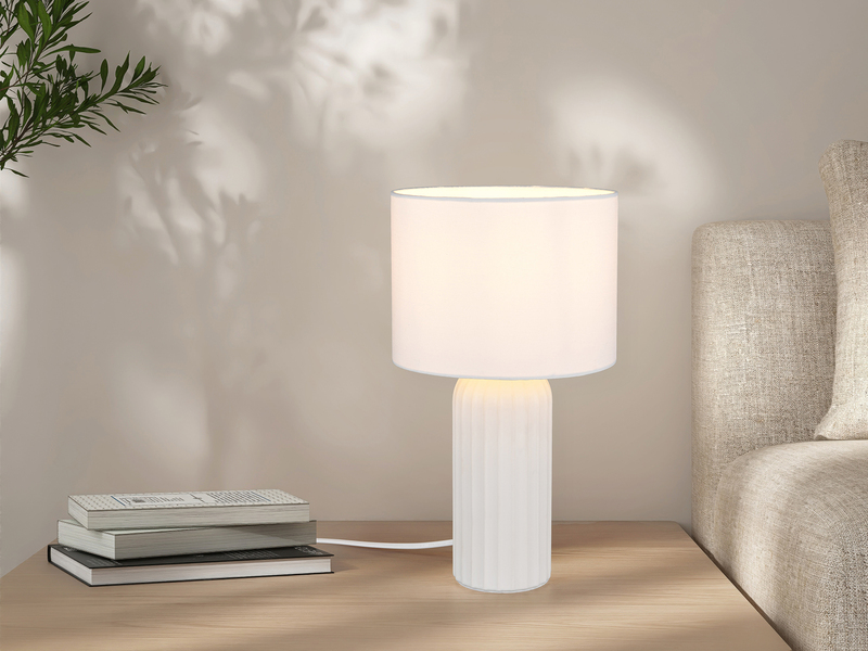 Weiße Tischleuchte mit Stoffschirm, auf einem Nachttisch im Schlafzimmer