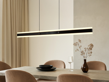 Lineare LED-Pendelleuchte in schwarz über einem Esstisch