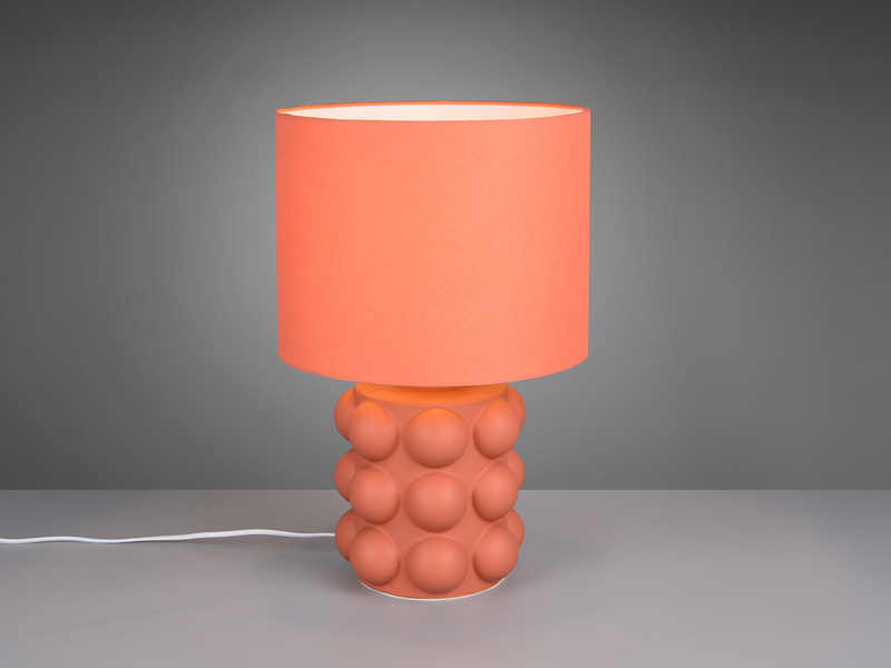 große orangene Retro-Tischleuchte mit kugelförmig strukturiertem Keramikfuß und Stoffschirm angeschaltet