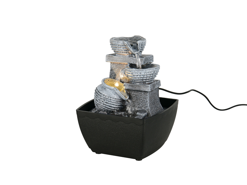 Zimmerbrunnen mit gestapelten Steinelementen und kleinem Wasserkrug als Freisteller