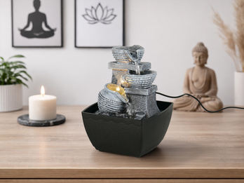 Zimmerbrunnen mit kleinem Wasserkrug in entspannter Meditationsumgebung