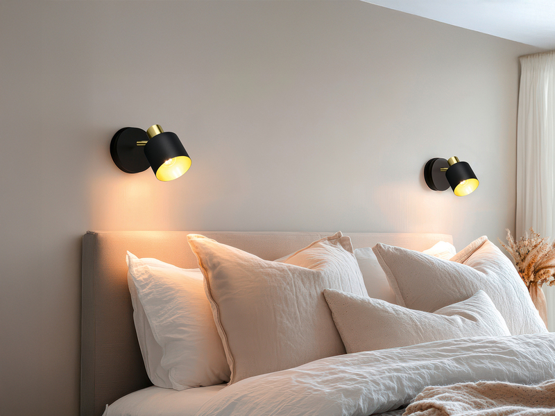 Zwei 1-flammige schwarz goldene Strahler am Bett montiert 