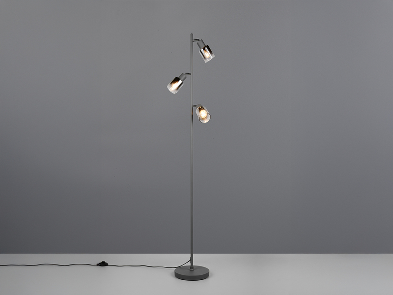 Stehlampe mit schwarzem Fuß und drei Chrom Glas Spots eingeschaltet im Raum stehend