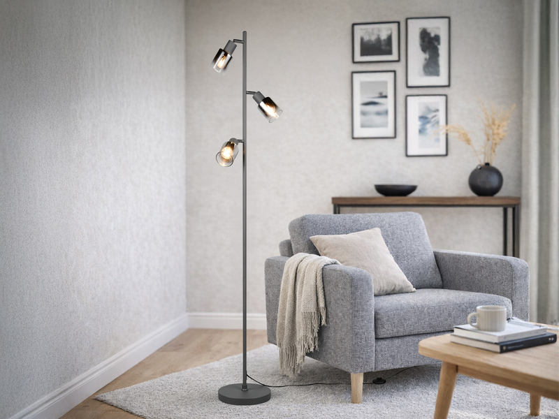 Stehlampe mit drei Chrom Glasspots in einem Wohnzimmer stehend