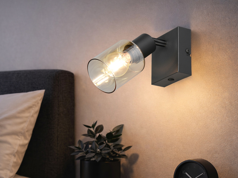 Wandstrahler mit amberfarbigem Glasschirm und schwarzer Montageplatte neben eine